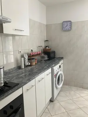 a kitchen with a washing machine and a clock on the wall at AkyaSpot in Praia