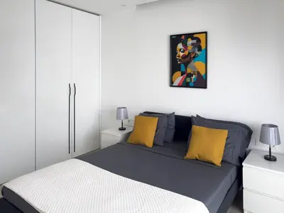 a bedroom with a bed with yellow pillows at Spacious 2 bdr aprt, rooftop pool - LCGR in Praia
