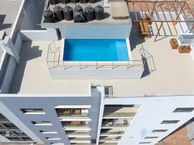 an aerial view of a building with a swimming pool at Spacious 2 bdr aprt, rooftop pool - LCGR in Praia