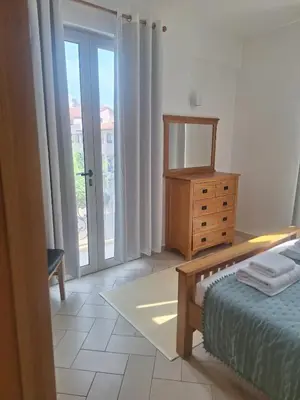 a bedroom with a bed and a dresser and a window at Apart T2 em frente à Praia - Centro de Santa Maria in Santa Maria