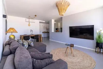 a living room with a large couch and a television at Mindelo Sunset Ocean Views near Laginha Beach in Mindelo