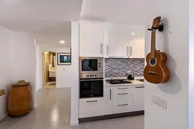 a kitchen with a guitar hanging on the wall at Mindelo Sunset Ocean Views near Laginha Beach in Mindelo