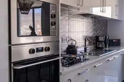 a kitchen with a stove and a microwave at Mindelo Sunset Ocean Views near Laginha Beach in Mindelo
