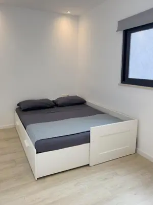 a white bed in a room with a window at Cozy 2 bdr aprt, rooftop pool - LCGR in Praia