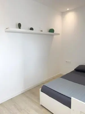 a white room with a bed and a shelf at Cozy 2 bdr aprt, rooftop pool - LCGR in Praia