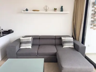 a living room with a couch and a table at Cozy 2 bdr aprt, rooftop pool - LCGR in Praia