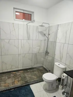 a bathroom with a white toilet and a window at I love TANK in Caculi