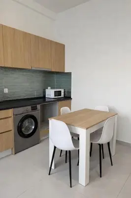 a kitchen with a wooden table and white chairs at AQUÁRIO Hotel in Sal Rei