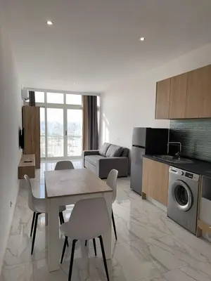 a kitchen and living room with a table and chairs at AQUÁRIO Hotel in Sal Rei