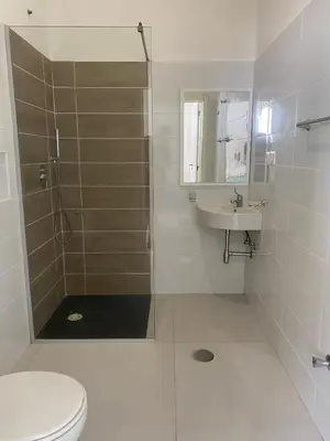 a bathroom with a shower and a toilet and a sink at AQUÁRIO Hotel in Sal Rei