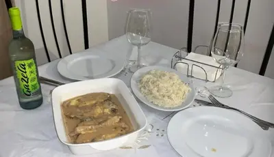 a white table with a bowl of food and wine glasses at HAC Apto in Praia