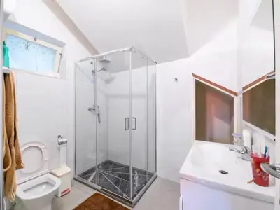 a white bathroom with a shower and a toilet at Casa Evora - Your home away from home in Mindelo
