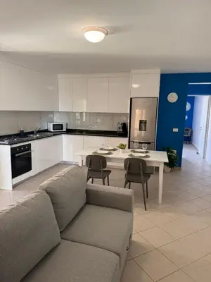 a living room with a couch and a kitchen at Estrela do Sul Santa Maria by RPG Group in Santa Maria