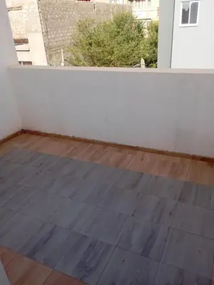 an empty room with a wooden floor and a window at Ti Jona Rooms in Mindelo