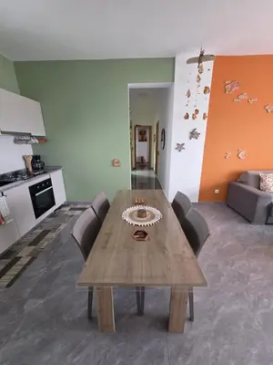 a wooden table in a living room with a kitchen at The Zen Den in Sal Rei