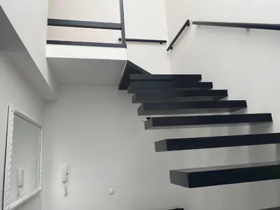 a black staircase in a white room with a window at Coraçon di Mindel Apartment in Mindelo