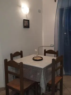 a dining room table with chairs and a plate on it at Holiday Properties Ca' Meli - Wi-fi in Santa Maria