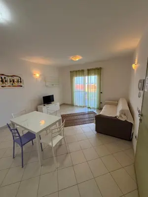 a living room with a table and a couch at Apartament POR DO SOL A9 praia Cabral wi-fi free Sal Rei in Sal Rei