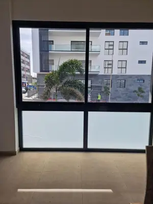 a large window with a view of a building at CV Edifício Vitória, RC Centro - PALMAREJO BAIXO in Praia