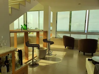 a living room with two bar stools in a building at C Varela C - Casa Branca in Praia