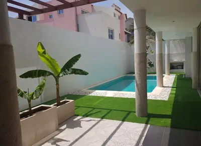 a courtyard with a swimming pool and palm trees at C Varela C - Casa Branca in Praia