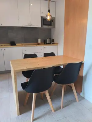 a wooden table with black chairs in a kitchen at HostySpot - Bloco Verde in Santa Maria