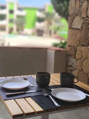 a wooden table with two cups and plates on it at HostySpot - Bloco Verde in Santa Maria