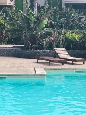 a wooden bench next to a swimming pool at HostySpot - Bloco Verde in Santa Maria