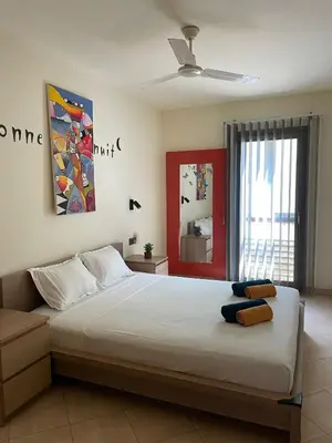a bedroom with a large white bed and a window at Central Santa Maria Sea view 2 Bedroomed Apartment in Santa Maria