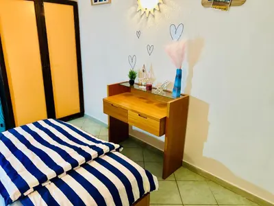 a room with a bed and a wooden table with a drawer at Santa Maria, 4min to Beach - Pool, AC, WiFi, De'Longhi coffee maker in Santa Maria