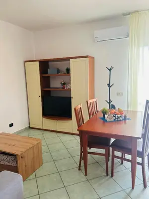 a dining room with a table and a tv at Santa Maria, 4min to Beach - Pool, AC, WiFi, De'Longhi coffee maker in Santa Maria