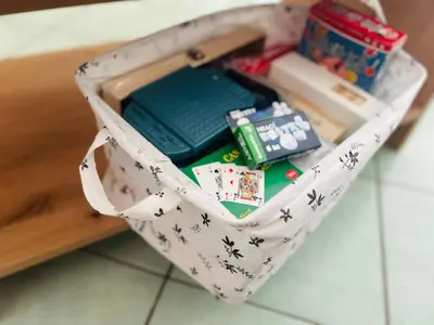 a white bag filled with playing cards and other items at Santa Maria, 4min to Beach - Pool, AC, WiFi, De'Longhi coffee maker in Santa Maria