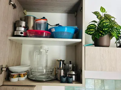 a cupboard filled with lots of kitchen utensils at Santa Maria, 4min to Beach - Pool, AC, WiFi, De'Longhi coffee maker in Santa Maria