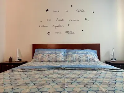 a bedroom with a bed with words on the wall at Rosa dei venti 4 in Santa Maria