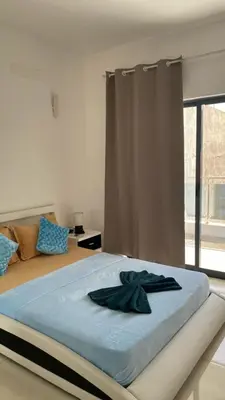 a bedroom with a large bed with a large window at Apartamento T3 palmarejo center in Praia