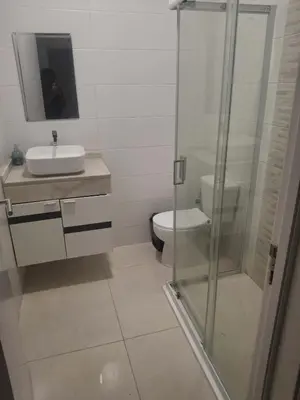 a bathroom with a toilet and a glass shower at Apartamento T3 palmarejo center in Praia