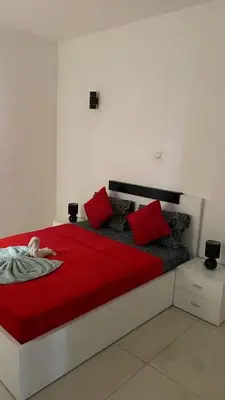 a bedroom with a large red bed with red pillows at Apartamento T3 palmarejo center in Praia