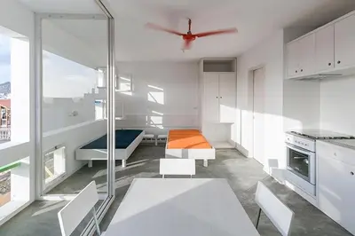 a kitchen with white cabinets and a ceiling fan at Modern Flat in Mindelo - 3B in Mindelo