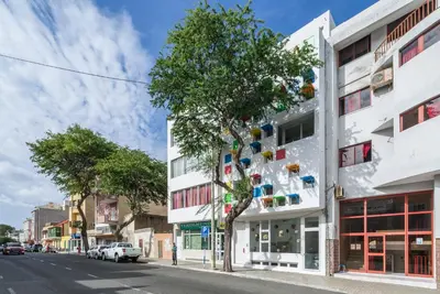 a building with a tree on the side of the street at Modern&Central Mindelo - 1A in Mindelo