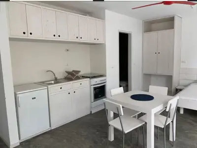 a kitchen with white cabinets and a table and chairs at Modern&Central Mindelo - 1A in Mindelo