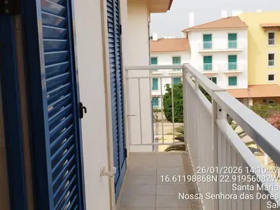 a balcony with a blue door and a view of a building at Mb HOUSE VILA VERDE RESORT in Prainha