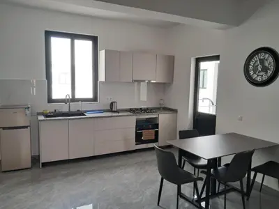 a kitchen with a table and chairs and a clock on the wall at Apartment T3 located Rua 4 de Julho Sal Rei blv in Sal Rei