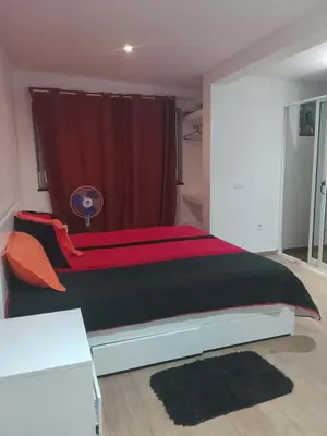 a large bed in a bedroom with a red curtain at Praia Sunset Horizon Apartment