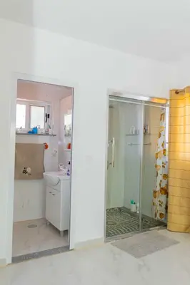 a bathroom with a shower and a toilet and a sink at Hospedaria Santo António in Praia Baixo