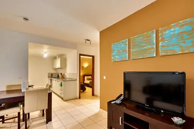 a living room with a flat screen tv on a wall at T2 Santa Maria, Ilha do Sal, Cabo Verde - Melia Tortuga Beach Resort in Prainha