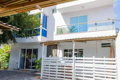 a white house with a fence in front of it at Hospedaria Santo António
