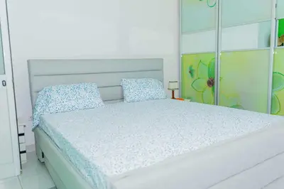 a white bed with blue pillows on top of it at Hospedaria Santo António