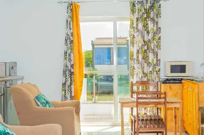 a living room with a table and chairs and a window at Hospedaria Santo António
