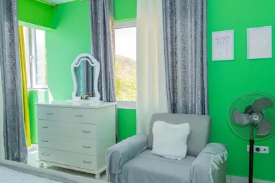a green room with a chair and a mirror at Hospedaria Santo António