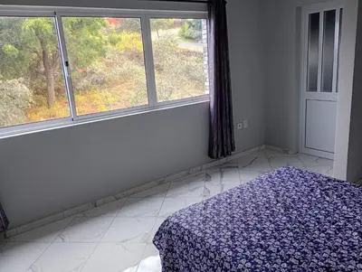 a bedroom with a bed and two windows at Campo do campo ocean view in São Filipe